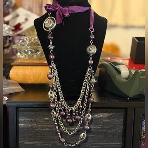 Three strand purple and silver tone necklace with ribbon fastener.
